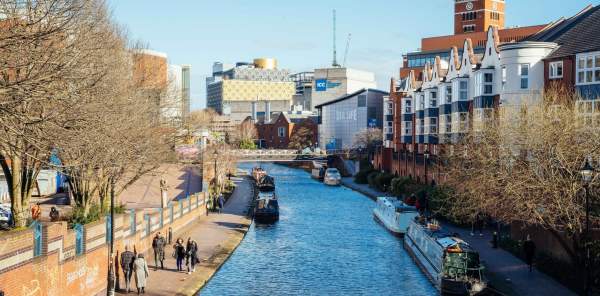 The canals in Brindleyplace during the day, with the Library in the distance