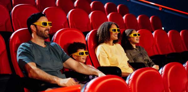 A family of four - Dad, son, mom, daughter sat in a cinema with 4D glasses on