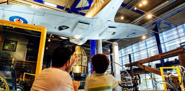 A father and son look up at the underside of a WWII plane in the ThinkTank in Birmingham