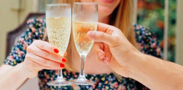 Two champagne flutes being held together in the air