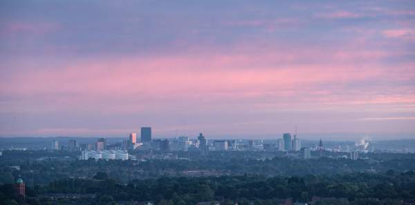 The Birmingham skyline in the far distance below a purple evening sky