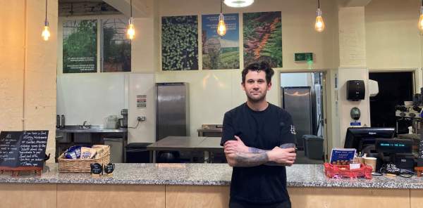 The owner of the Hive standing in front of the counter