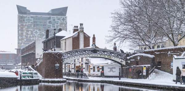 Winter in Birmingham, snow on the ground and bridge with the Regency Wharf and Cube in the background