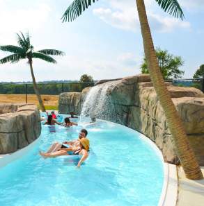 Children and adults float down a cool, blue lazy river at Parrot Island Water Park in Fort Smith.