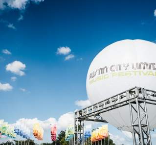 large balloon reading Austin City Limits Music Festival with colorful flags at ACL Fest in austin texas