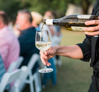 Man pouring wine at Austin Food and Wine Festivals Feast Under the Stars event in Austin Texas