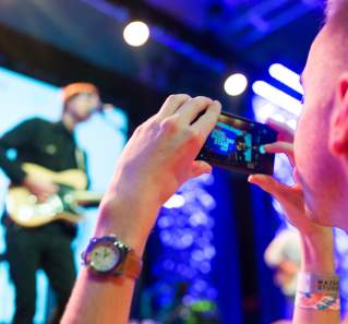 Man takes photo of band on stage at SXSW Music Festival