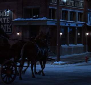The Newton Boys screengrab showing a horse-drawn carriage in front of the Bartlett National Bank with signs reading Hondo State Bank