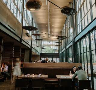 Image of the interior of Comedor with people dining at the tables.