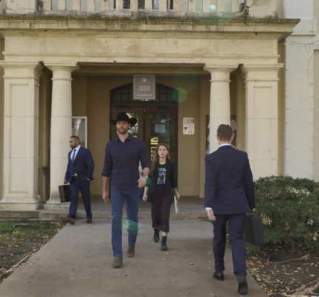 Walker screengrab showing Walker walking out of a white stone courthouse