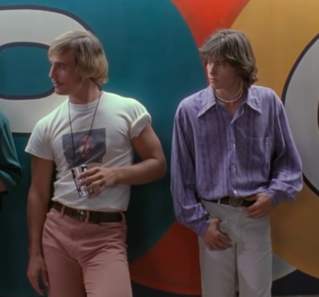 Screengrab from Dazed and Confused showing actors Sasha Jensen, Matthew McConaughey, Jason London and Wiley Wiggins standing up against the wall at the Emporium