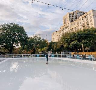 Woman skating on shiny ice outside of the Four Seasons Hotel Austin.