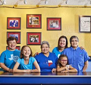 Regina Estrada and female family members smile for a portrait inside Joes Bakery and Coffee Shop
