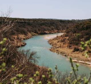 View of winding river and greenery-covered banks at Reimers Ranch.