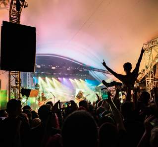 The silhouette of a crowd and someone crowd surfing during a concert at Stubb's.