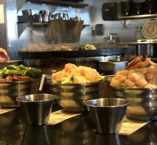 bowls of meat and vegetables ready for a hibachi grill