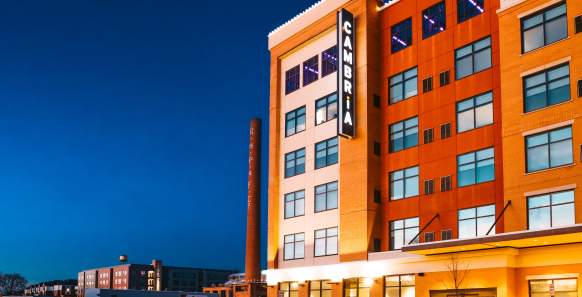 The exterior of a lit up orange-brown hotel at nightfall