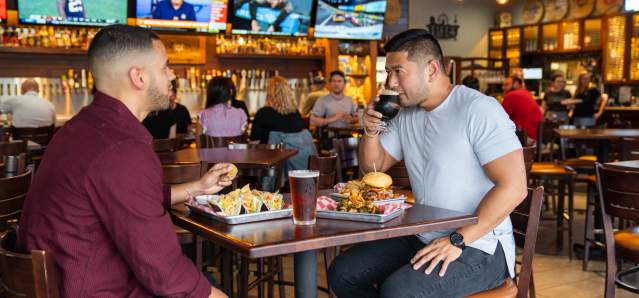 two men enjoying beer and food at 859 taproom