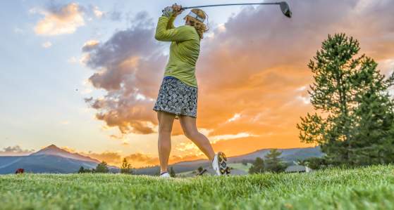 Women golfing with sunset