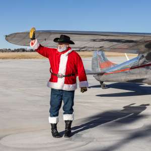 Santa waves from an airplane on the runway