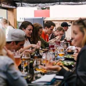 People at long table getting together at local restaurant to share meal