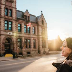 Happy woman in front of a building