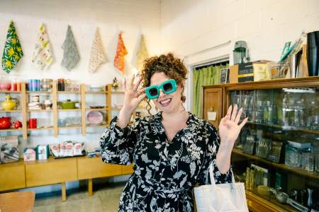 A woman tries on a pair of sunglasses in And Stuff