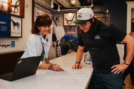 A visitor information specialist assisting a visitor at the counter