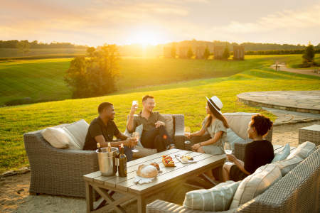 Friends enjoying a Wine Tasting Stone Tower with the sunset in the distance