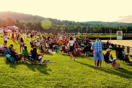 Crowd gathered on the hillside lawn at Morven Park in Loudoun for a summer polo match at sunset