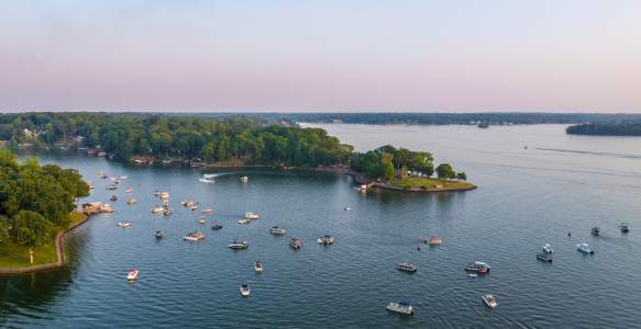 Lake with many boats on it with a piece of land seen
