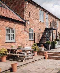 Accommodation exterior with picnic benches and plants