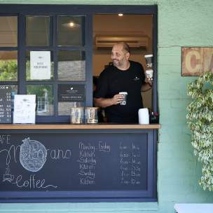 Man serves coffee from a cafe in Subiaco Perth City
