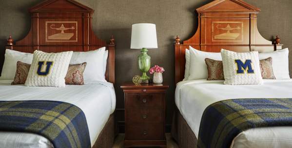 Two beds with U-M pillows at Graduate Ann Arbor