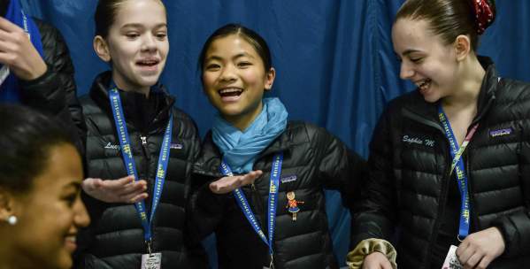 Group of three young ice skaters smiling