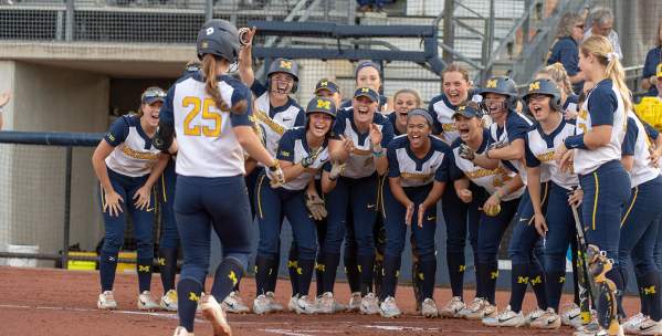 U-M Softball team cheering on player coming into home plate