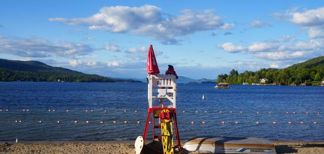 Lifeguard chair on the beach facing Lake George and Adirondack Mountains