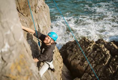 Man abseiling along coastal cliffs