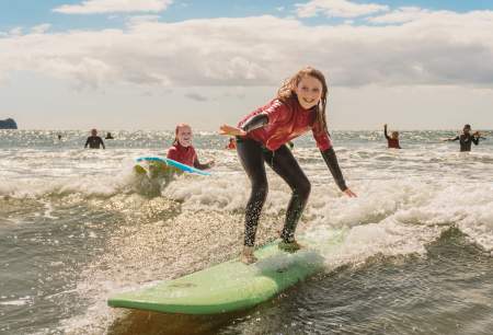 young girls surfing in rhossili bay