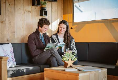 couple sitting on sofa reading book