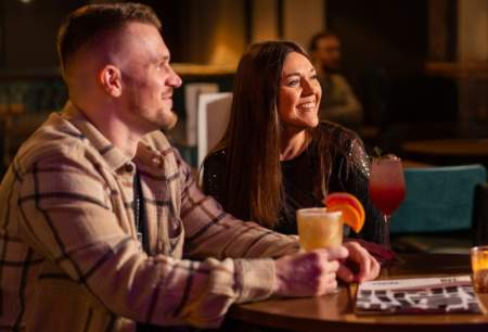 Couple sat with drinks in a bar