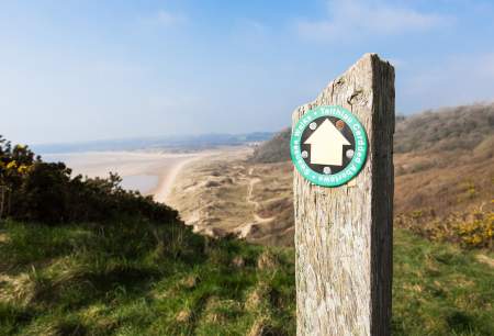 Walking sign post with Crawley beach in the background.