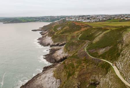 Drone shot of the rugged coastline of Gower with the coast path winding along.