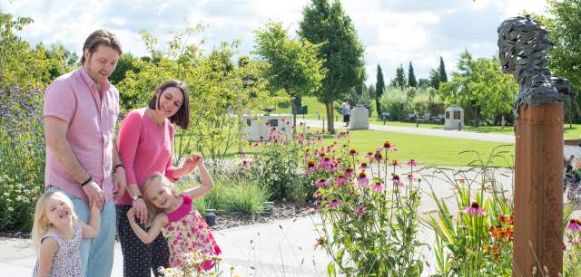 Family walking through colourful gardens at the National Memorial Arboretum.