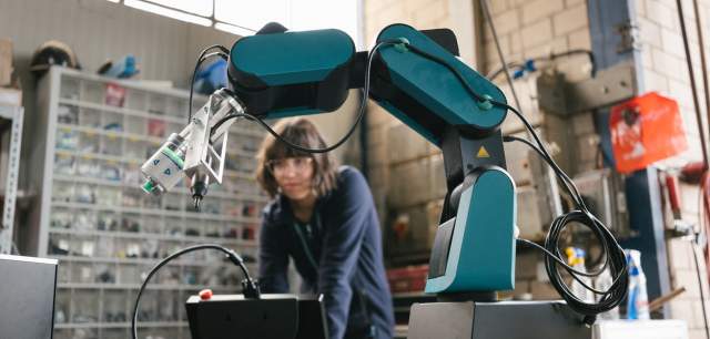 Person in a workshop, working on a robot