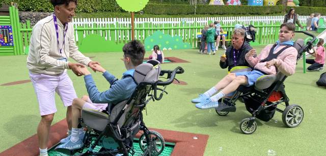 a queue of visitors in wheelchairs wait for the trampoline at CBeebies Land
