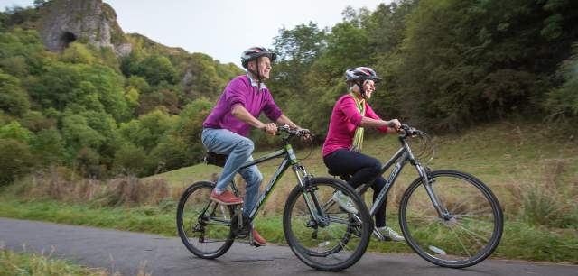couple on a bike ride with Thor's Cave in background