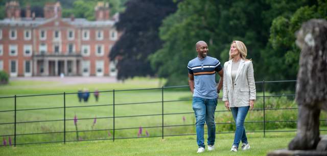 couple walking the grounds with the House in the background