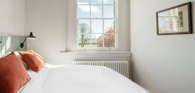 Indoor shot of double bed in bedroom with picturesque view through window taken at Constantine House