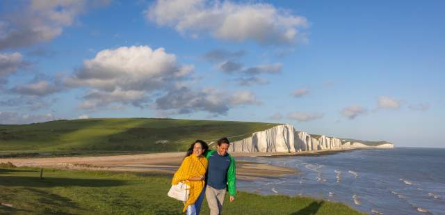 A man and woman walk along the cliffs at Seven Sisters, Sussex